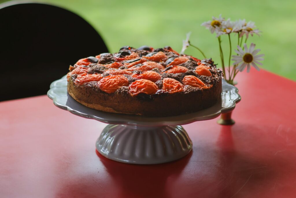 Glutenfreier Marillen-Mohnkuchen mit frischen Marillen und Mohn auf einem Kuchenteller